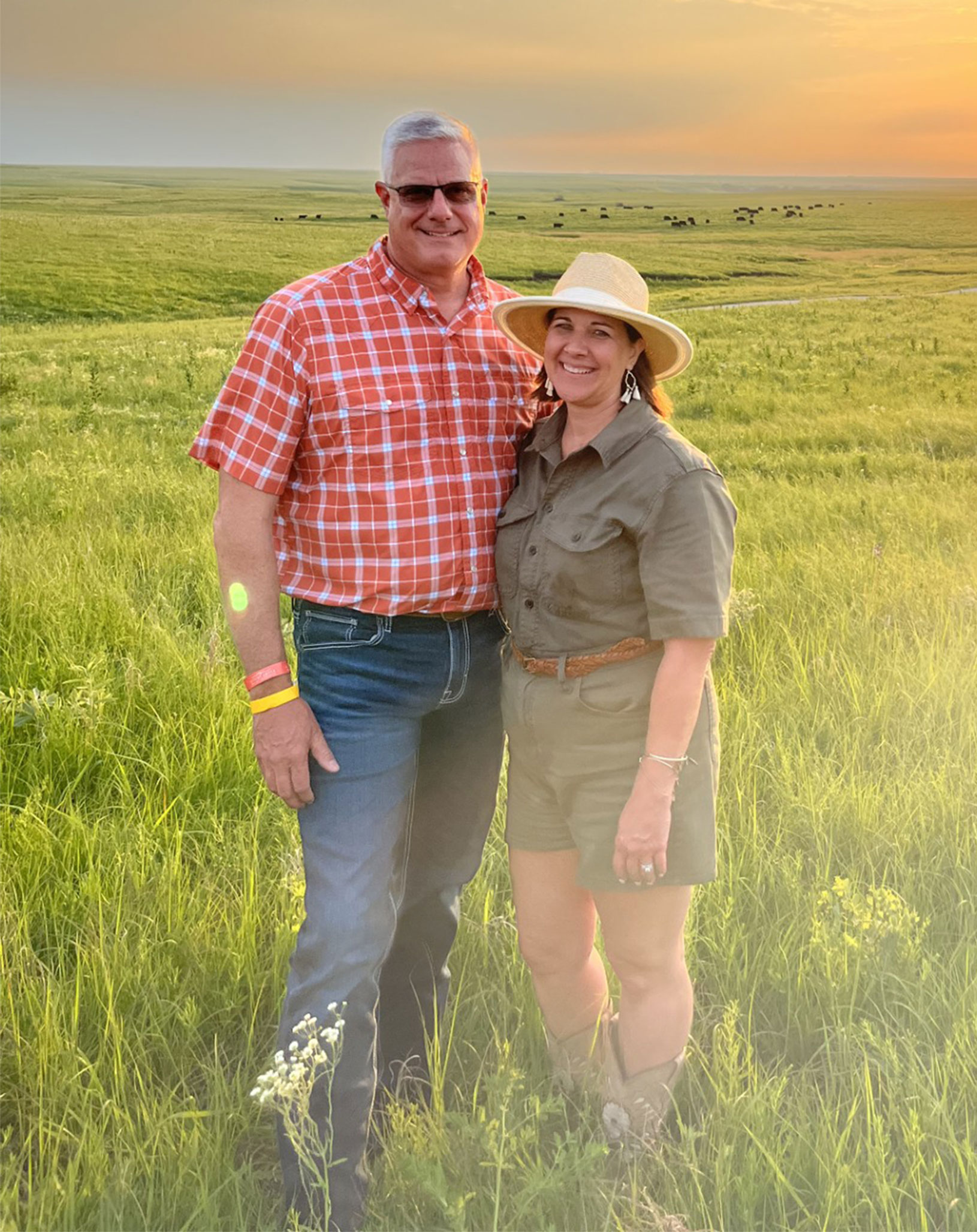 about Wes and Amy Sawyer in a green pasture smiling at the camera